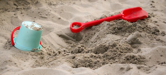 Sandkasten mit Schaufel und Eimer