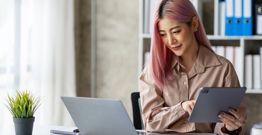 Portrait of a young Asian businesswoman working on a tablet with a laptop at the thinking office. analyze marketing data online business ideas.