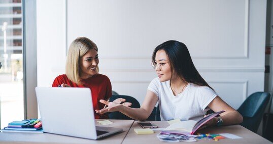 Multiethnic women working with laptop in office