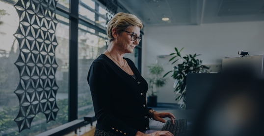 Senior businesswoman working at standing desk in office