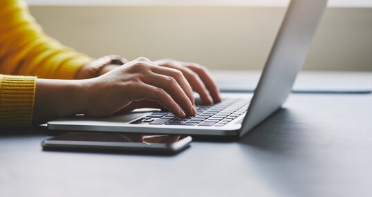 Close up of female hands while typing on laptop