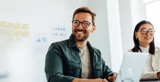 Happy business man listening to a discussion in an office