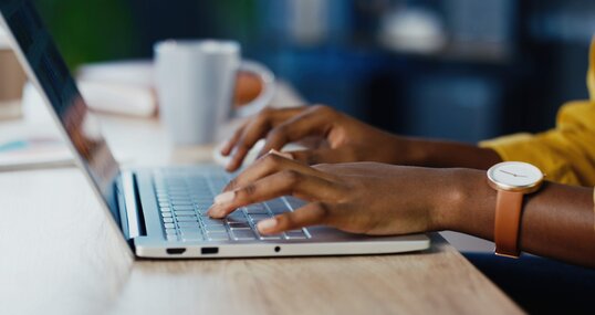 Close up shot of female hands typing on laptop